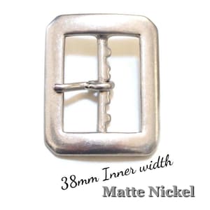 May include: Matte nickel rectangular belt buckle with a 38mm inner width (approx. 1.5 inches). The buckle features a classic design with a central bar and a prong. The metal has a brushed finish.