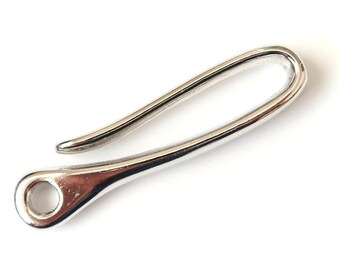 Pode incluir: Um gancho de chaveiro de metal prateado com um design curvo e liso. O gancho tem um pequeno laço em uma extremidade para prender as chaves.