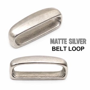 May include: Two matte silver belt loops with a smooth, rounded rectangular shape. The text MATTE SILVER BELT LOOP is printed in black and gray to the right of the top loop. The metal components have a consistent, dull metallic finish.