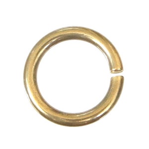 May include: A gold-colored metal jump ring, a type of jewelry finding used for connecting chains, cords, or other jewelry components.