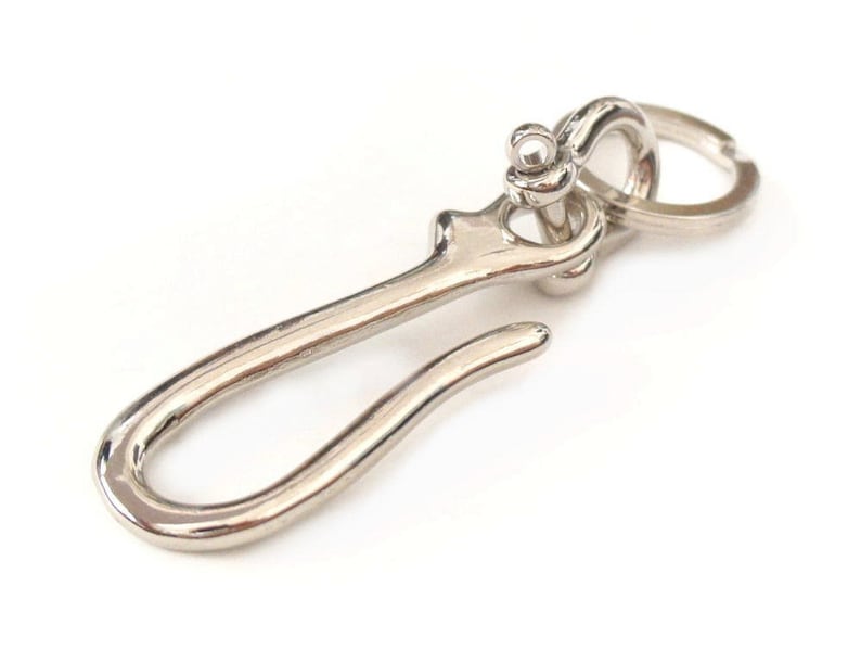 Op de afbeelding: Zilveren sleutelhanger met een haak en een ring. De haak is gebogen in de vorm van een S.