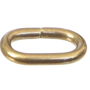 May include: A gold-colored oval-shaped metal connector link.