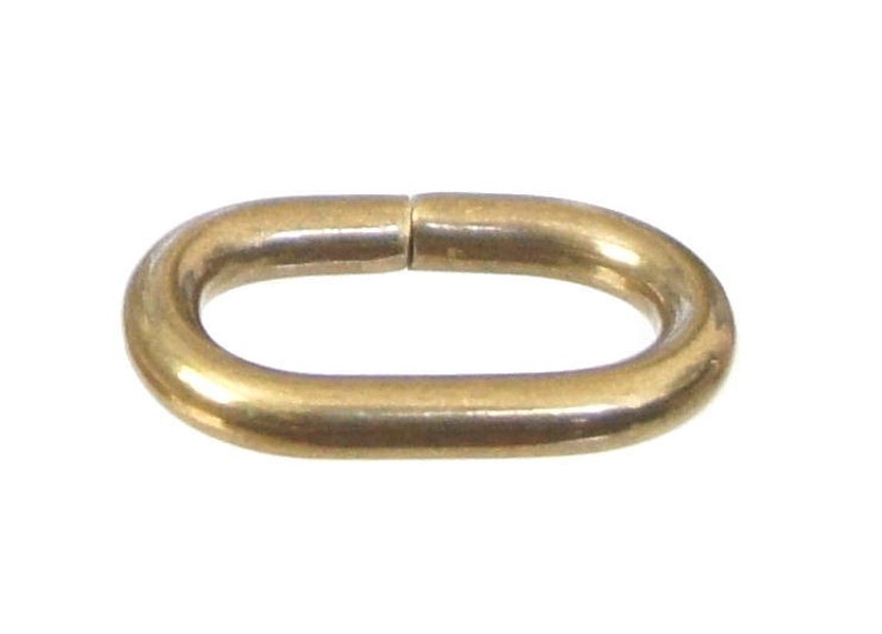 May include: A gold-colored oval-shaped metal connector link.