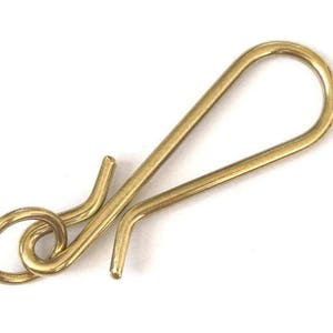 Può includere: Un gancio in metallo dorato con un anello ad un'estremità e un gancio all'altra.