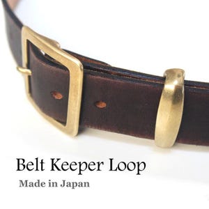 May include: A brown leather belt with a brass buckle and keeper loop. The belt is made in Japan. "Belt Keeper Loop" and "Made in Japan" are printed on the bottom of the image.