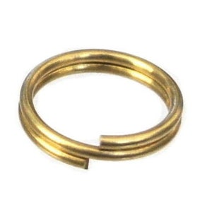 May include: A gold-colored metal jump ring, a type of jewelry finding used for attaching charms, pendants, or other jewelry components.