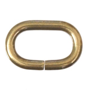 May include: A gold-colored oval metal ring with a smooth finish. The ring is open on one side, allowing it to be attached to other items.