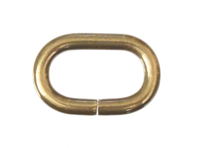 May include: A gold-colored oval metal ring with a smooth finish. The ring is open on one side, allowing it to be attached to other items.