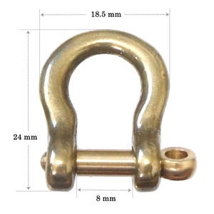 May include: A gold-colored metal D-ring with a diameter of 18.5 mm, a height of 24 mm, and a width of 8 mm.