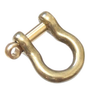 May include: A gold-colored metal u-shaped clasp with a pin. The clasp is smooth and shiny.