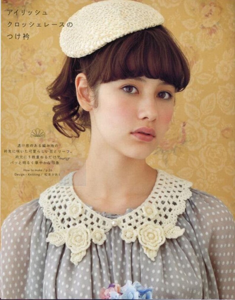 May include: A white crocheted collar with a delicate floral design. The collar is worn over a grey polka dot blouse. The text "アイリッシュ クロッシェレースの つけ衿" is visible in the image.