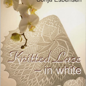 Pode incluir: Capa de livro com um tapete de renda branca de tricô com o título "Knitted Lace - in white" e o nome do autor "Sonja Esbensen".