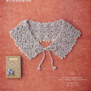 May include: A crocheted collar with a pearl trim and a tie closure. The collar is a light grey colour and is shown on a red background.