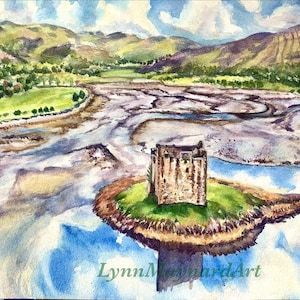 Op de afbeelding: Waterverf schilderij van een stenen kasteel op een klein eiland in een rivier. De rivier wordt omringd door groene heuvels en een blauwe lucht met witte wolken. Het schilderij is onderaan rechts gesigneerd met "Lynn Maynard Art".