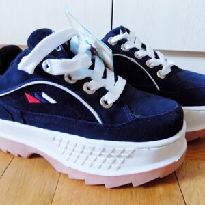 May include: A pair of navy blue platform sneakers with white laces and a white sole. The sneakers have a pink outsole and a small logo with red, white, and blue accents. The shoes are new with tags.