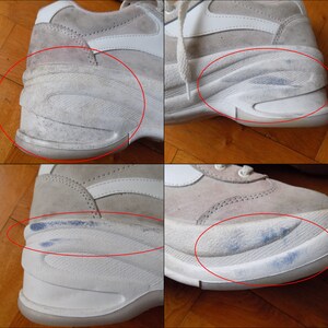 May include: Close-up of a pair of worn, off-white sneakers. The shoes have a suede upper with white accents and a thick, textured sole. Visible wear and tear includes scuff marks and discoloration on the soles and uppers.