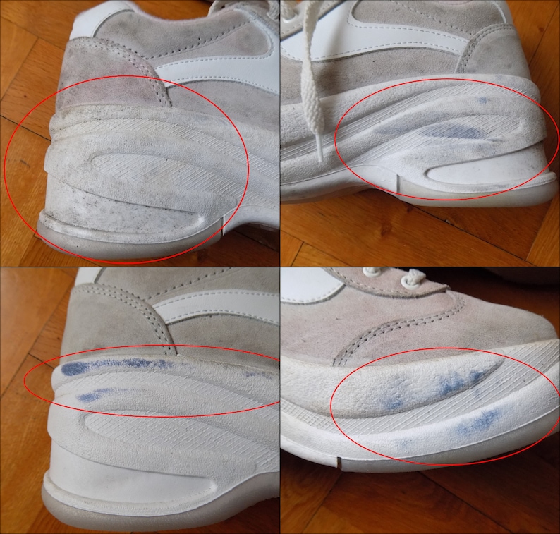 May include: Close-up of a pair of worn, off-white sneakers. The shoes have a suede upper with white accents and a thick, textured sole. Visible wear and tear includes scuff marks and discoloration on the soles and uppers.