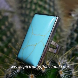 May include: A turquoise stone ring with a silver band. The stone is rectangular and has a marbled pattern.