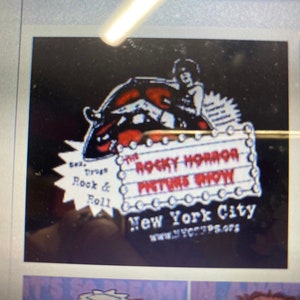 May include: A black and red graphic for "The Rocky Horror Picture Show" with a stylized image of a person and text. The text includes "Sex, Drugs, Rock & Roll" and "New York City". The website www.nycRPS.org is also visible.
