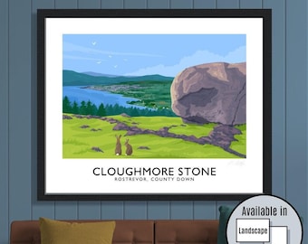 May include: Framed art print of Cloughmore Stone, Rostrevor, County Down. The landscape artwork shows a large boulder, green fields, a town, and water under a blue sky. Two rabbits are in the foreground. Text reads "Cloughmore Stone".