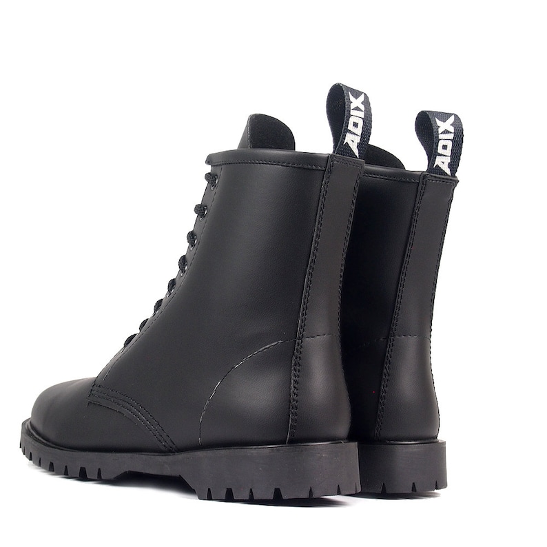 May include: Black leather combat boots with a lace-up design and a thick, lugged sole. The boots have a pull tab at the back with the word "ADIX" in white. The boots are shown from the side and back against a white background.