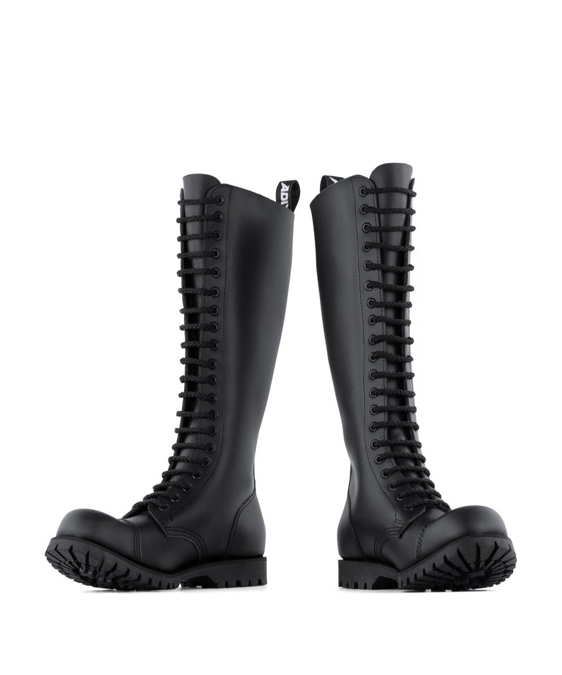 May include: Two black leather knee-high boots with a lace-up design. The boots have a rounded toe and a thick, lugged sole. The boots are approximately 40 cm tall and feature the word "ADI" on the top of the boot.