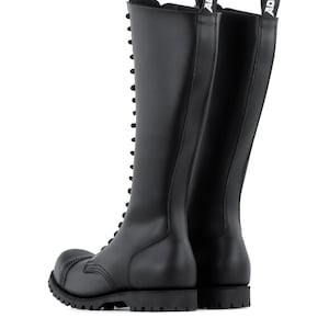May include: Black leather knee-high boots with a lace-up design and a thick, lug sole. The boots have a rounded toe and a pull tab at the top with the brand name "ADIX" in white. These boots are designed for durability and style.