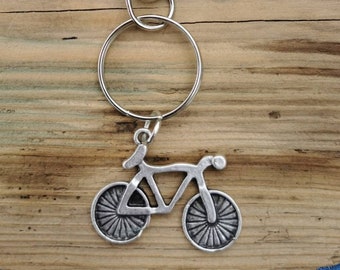 May include: Silver bicycle keychain with a split ring and a lobster clasp.