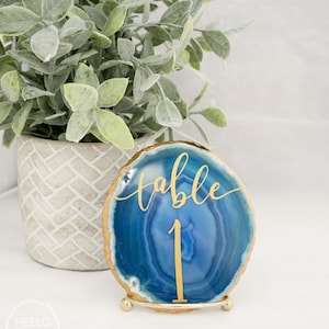 May include: Blue agate table number holder with gold foil lettering that says "table 1".