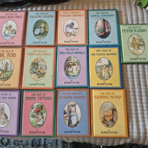 May include: A collection of thirteen Beatrix Potter hardcover books featuring colorful illustrated covers with titles such as The Tale of Peter Rabbit, The Tale of Two Bad Mice, The Tale of Mr. Tod, and The Tale of Squirrel Nutkin, arranged in a grid.