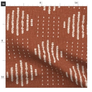 Könnte beinhalten: Ein rostfarbener Stoff mit einem weißen geometrischen Muster. Das Muster besteht aus Reihen kleiner Kreise und Linien.