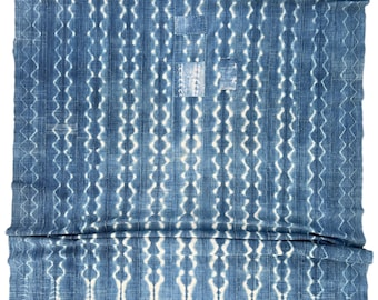 Rustic faded blue Mud Cloth throw with patches and hand stitching. Hand made shibori stripes