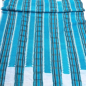 May include: A white and blue fabric with a striped pattern. The fabric has a geometric design with small triangles and lines.