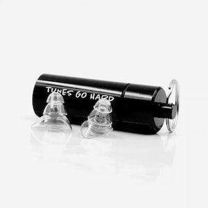 May include: Black earplug case with the text "TUNES GO HARD" printed on it. The case has a small metal ring attached to it. Two clear earplugs are shown in front of the case.