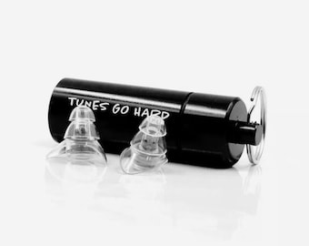 May include: Black earplug case with the text "TUNES GO HARD" printed on it. The case has a small metal ring attached to it. Two clear earplugs are shown in front of the case.