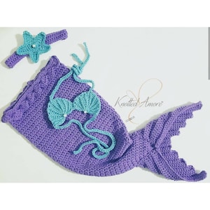May include: Purple crocheted mermaid tail with a matching blue crocheted seashell bikini top and a starfish headband. The headband has a pearl in the center.