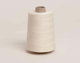 Raw unbleached cotton overlocker spool on cardboard cone with paper wrap. 100% Plastic free and biodegradable