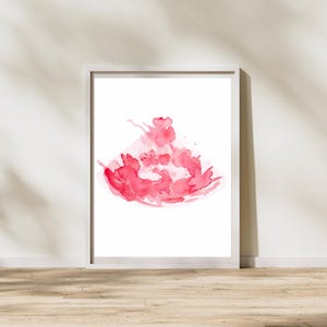 Può includere: Una stampa ad acquerello incorniciata con un vivace design astratto nei toni del rosso. L'opera d'arte presenta una composizione dinamica di schizzi e lavaggi, creando un pezzo visivamente accattivante. La stampa è su sfondo bianco.