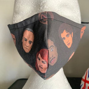 May include: Black face mask with a repeating pattern of colorful cartoon faces.