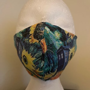 May include: A blue and yellow face mask with a print of sunflowers and a blue TARDIS from the Doctor Who television series.