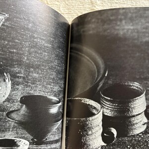 May include: Black and white photograph of various ceramic vessels. The image includes a tall vase, a round vessel, a small bowl, and two mugs with handles. The vessels have a textured, rustic appearance.