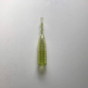 Puede incluir: Una botella de vidrio transparente con un diseño en espiral amarillo.