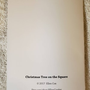 May include: A cream-coloured greeting card featuring the text "Christmas Tree on the Square" in black. The card also includes the copyright information: &copy; 2017 Ellen Cox and the Etsy shop URL.