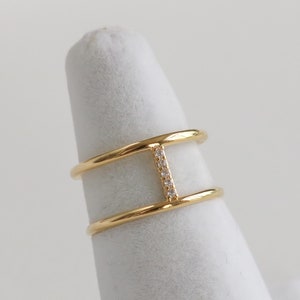 May include: Gold ring with a double band and a row of small clear stones in the centre.