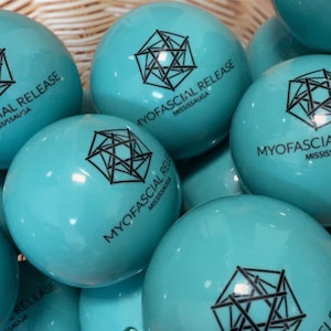 Peut inclure: Un groupe de balles bleu turquoise avec un motif géométrique noir et le texte "MYOFASCIAL RELEASE MISSISSAUGA" imprimé dessus.
