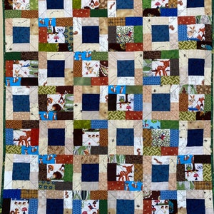 May include: A patchwork quilt with a woodland theme. The quilt is made up of squares of different fabrics, each featuring a different woodland creature or object. The quilt is in shades of brown, green, blue, and white.
