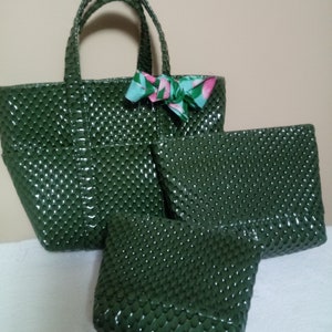 May include: Three green faux leather handbags with a textured, scaly pattern. The largest bag has a bow made of fabric with a floral print.