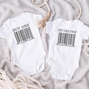 Peut inclure: Deux bodies de bébé blancs à manches courtes. L'un porte le texte "BUY ONE" au-dessus d'un code-barres, et l'autre dit "GET ONE FREE" au-dessus d'un code-barres. Les deux ont le numéro "012045 478101" en dessous.