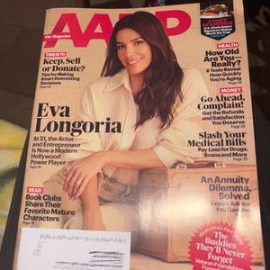May include: AARP magazine cover featuring Eva Longoria. The cover includes headlines such as "Keep, Sell or Donate?" and "How Old Are You - Really?" The magazine has a red and white logo and is dated April/May 2026.