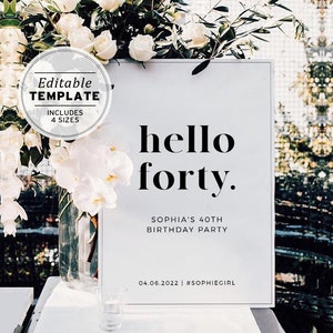 May include: White sign with black text that reads "hello forty."  The sign also includes the text "Sophia's 40th Birthday Party" and "04.06.2022 | #SOPHIEGIRL". The sign is in front of white flowers.